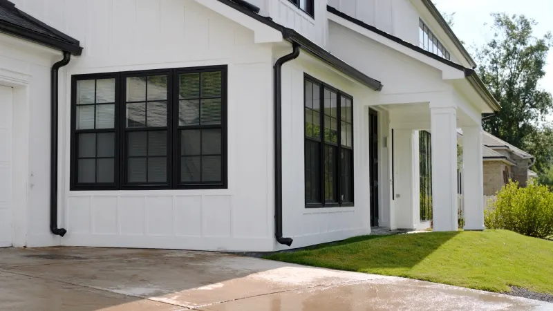 Modern farmhouse with matte black seamless gutters on a new suburban street in Alpharetta, GA
