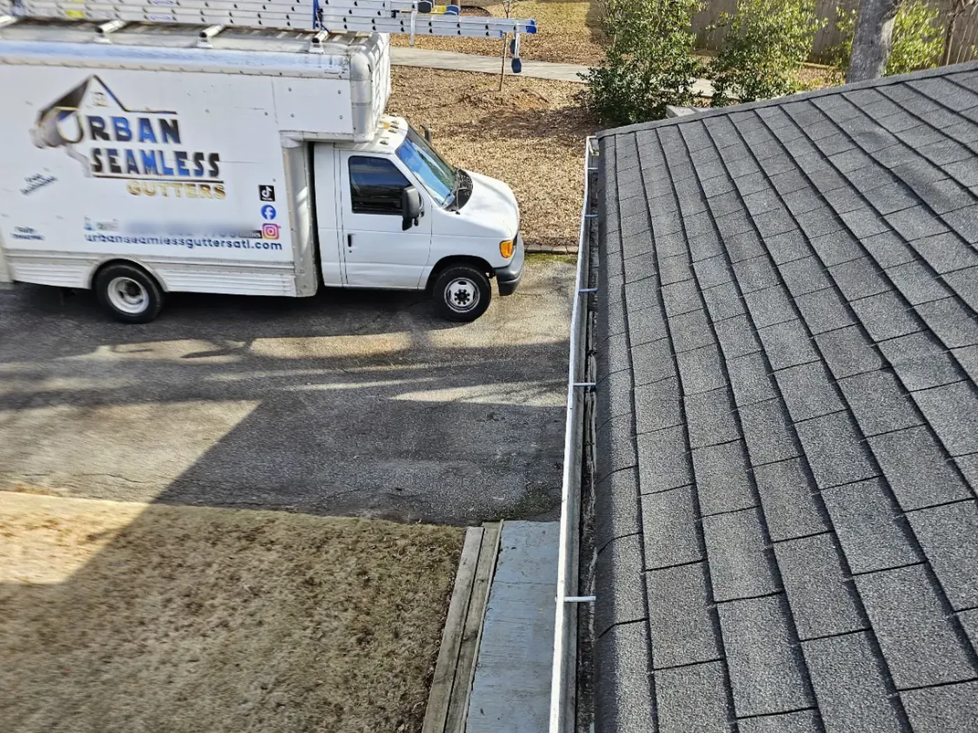 Crisp, clean seamless gutter line along an Atlanta roofline — workmanship backed by a 20-year labor guarantee