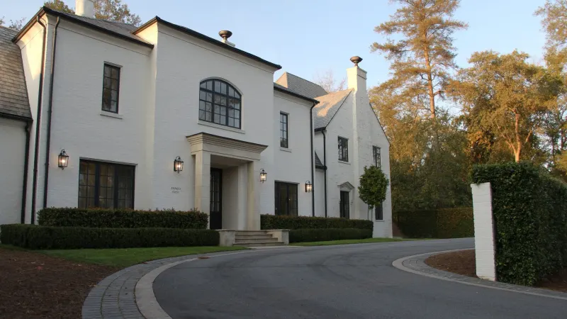 Luxury white-brick Buckhead estate with black seamless gutters and manicured boxwood hedges — Buckhead, Atlanta, GA