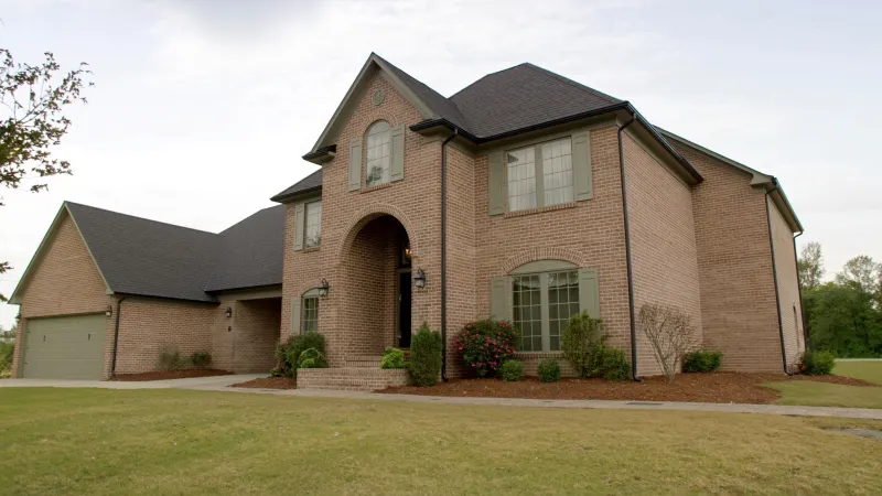 Stately two-story brick traditional with black seamless gutters on a Gwinnett County cul-de-sac — Duluth, GA