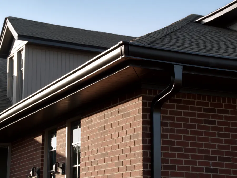 New matte black seamless gutters and downspouts installed on a brick Fairburn, GA home