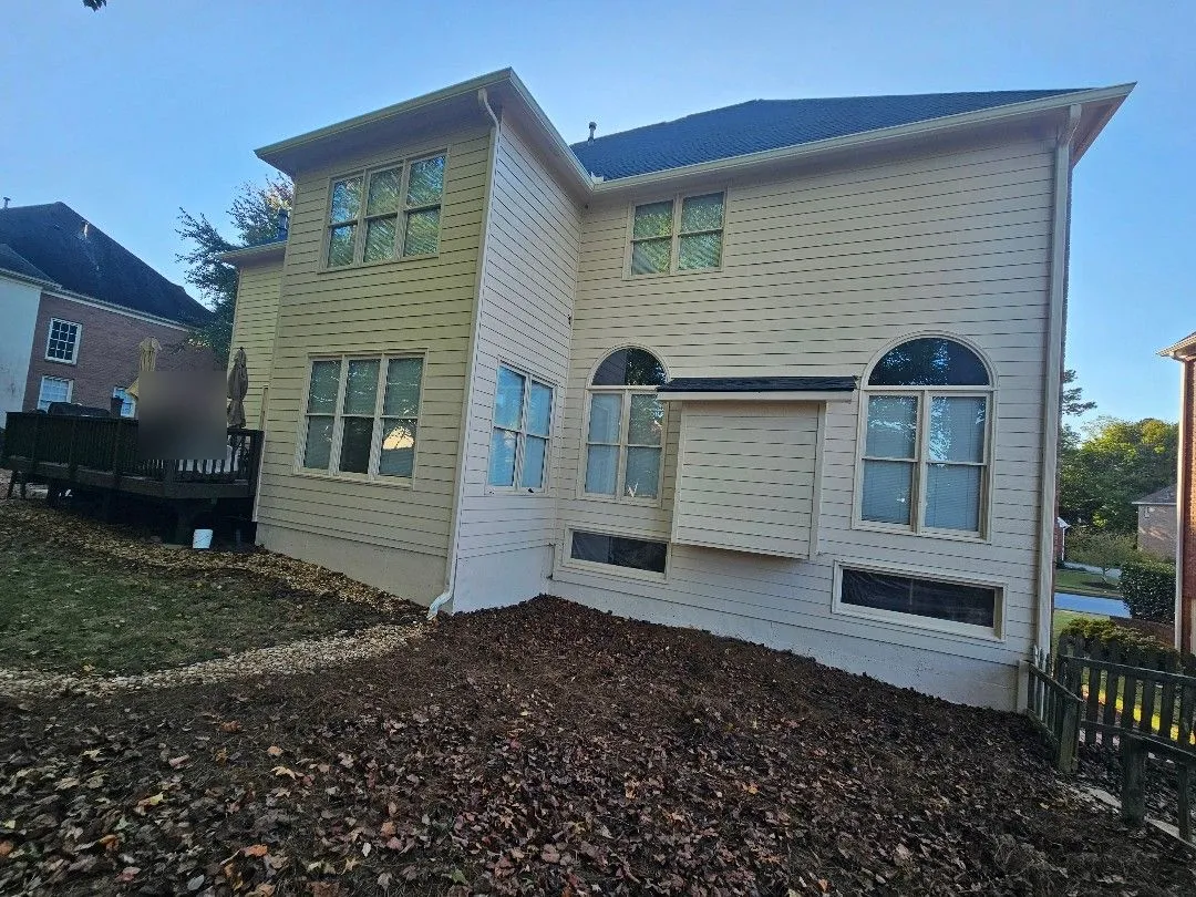 Rear corner of the house with gutters on two roof levels and a downspout to the ground, in Alpharetta, GA