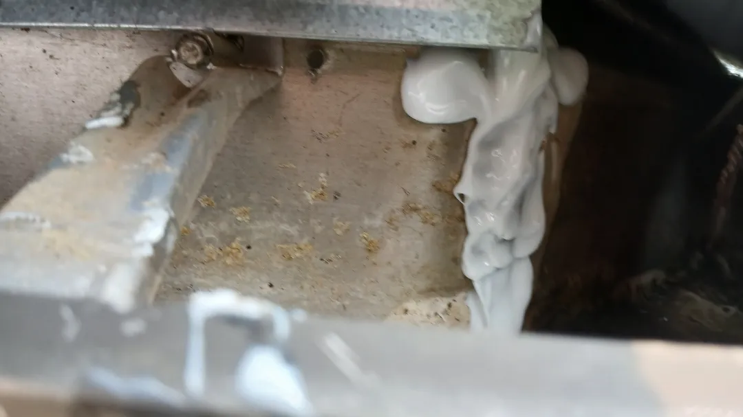 GeoCel gutter sealant applied along a seam inside a gutter, next to a hanger, in Alpharetta, GA