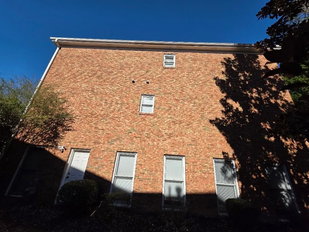 Three-story brick side wall with a long gutter run at the roofline, in Alpharetta, GA