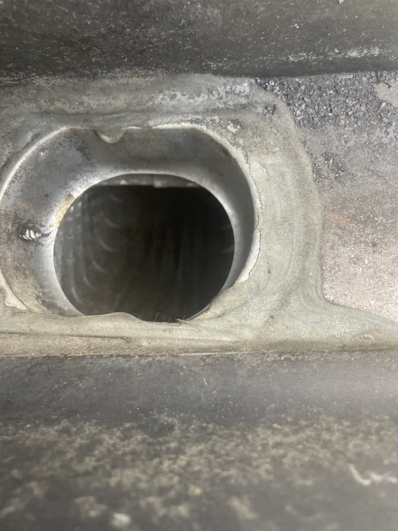 Close-up looking down a downspout outlet in the bottom of a gutter at an Atlanta, GA townhome