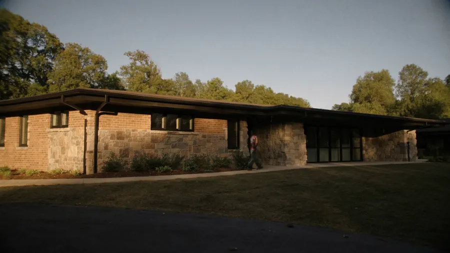 Brick ranch with granite stone accents in Lithonia, GA fitted with new black seamless gutters in DeKalb County