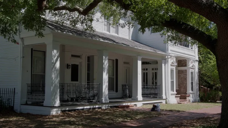 Historic-district Roswell home with white seamless gutters under mature hardwoods — Roswell, GA