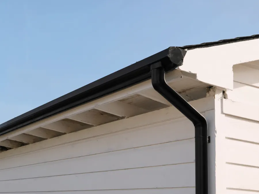Matte black seamless gutters installed on a new-construction Suwanee, GA home with board-and-batten siding